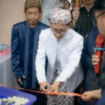 Suasana acara grand opening dengan pemotongan pita oleh pemilik usaha